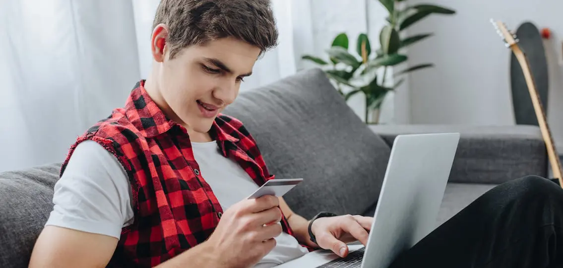 Boy On Computer Using Credit Card